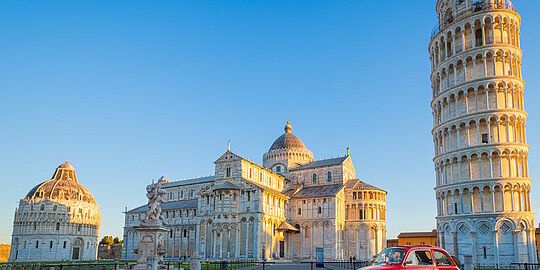 Auto, im Hintergrund der schiefe Turm von Pisa, in Italien