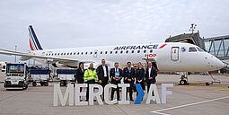 Flughafen-Chef steht mit der Crew und großen Buchstaben ("Merci AF") vor dem Flugzeug der Air France.